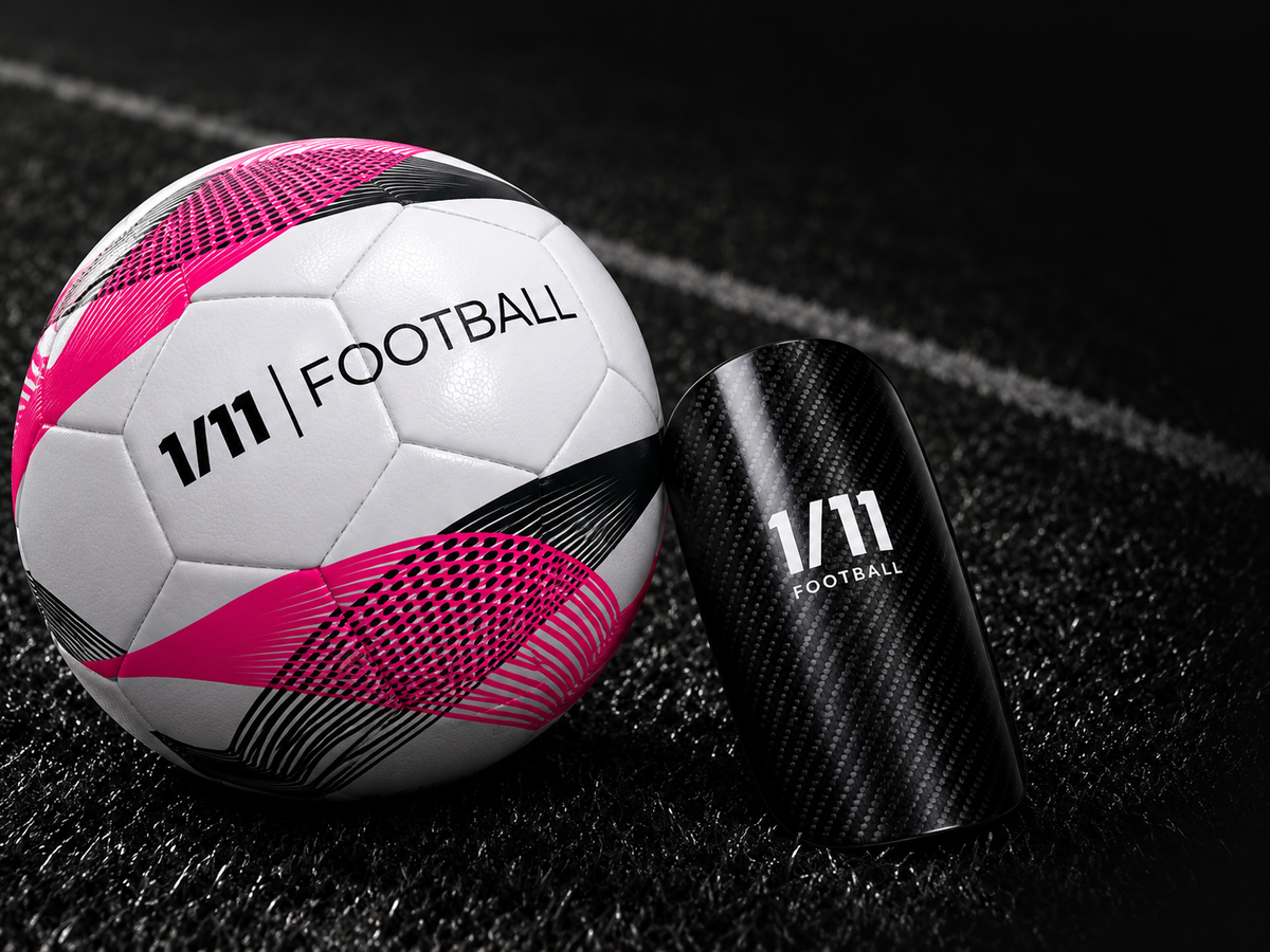 ONE OF ELEVEN football and carbon shin pad on a dark football pitch